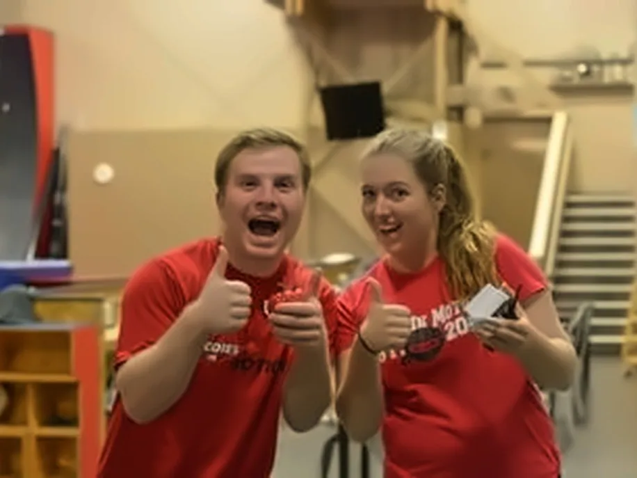 Two Bodies in Motion staff in red shirts giving thumbs up in the gym